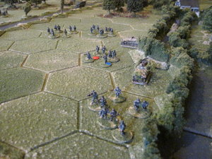 German infantry sections advance in the open ground next to the bocage lane