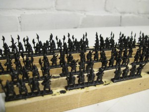 Ming armoured infantry spray painted satin black and mounted on wood strips ready for painting.